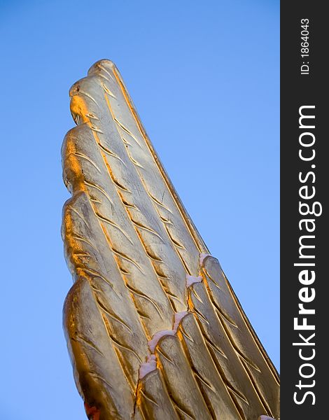 Wing of a statue of a griffin in St.-Petersburg on a background of the sky. Wing of a statue of a griffin in St.-Petersburg on a background of the sky