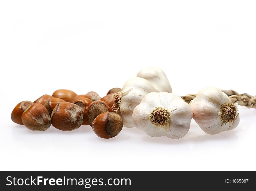 Pieces of garlic and hazelnuts isolated on white background