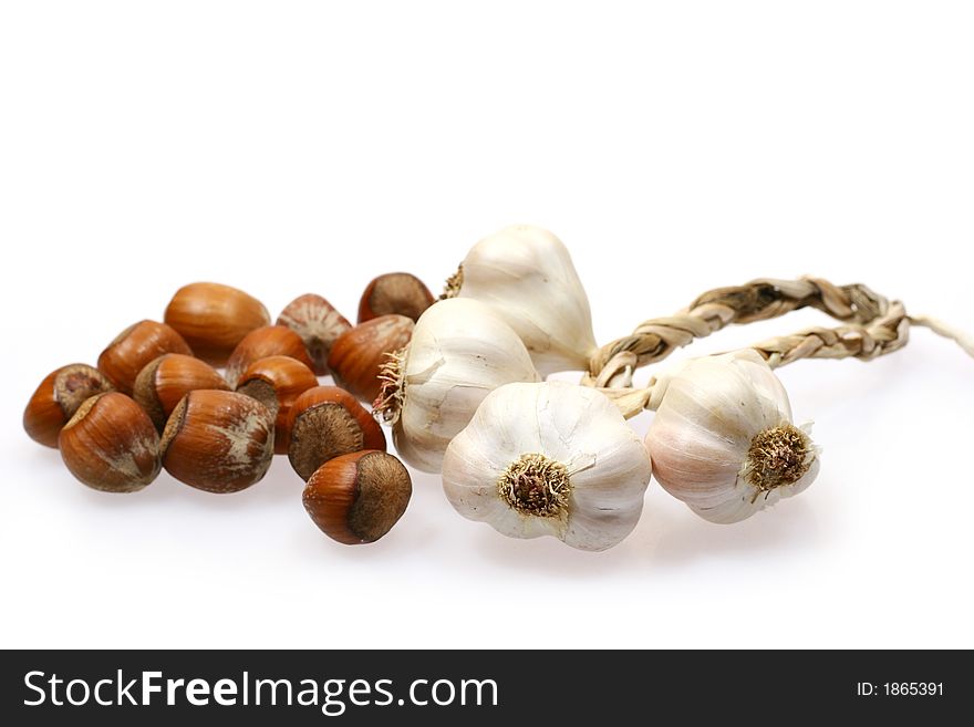 Pieces of garlic and hazelnuts isolated on white background
