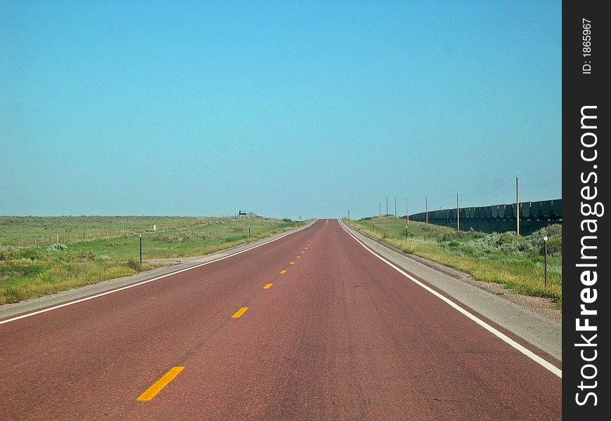 Red pavement heading west through Wyoming State. Red pavement heading west through Wyoming State