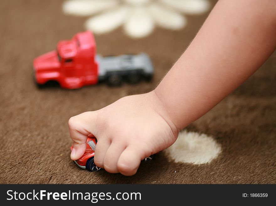 A three year old kid's close-up playing his toys. Can also be a conceptual image of competition instead of direct child's play image. A three year old kid's close-up playing his toys. Can also be a conceptual image of competition instead of direct child's play image
