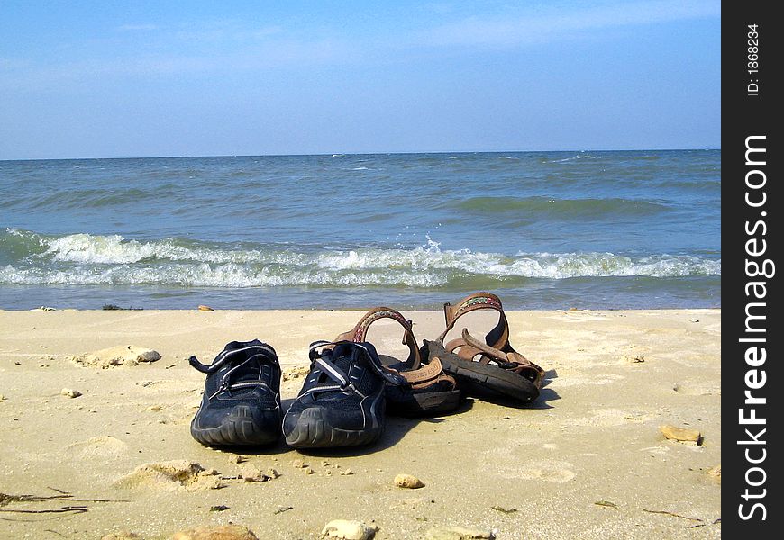 Two pairs of shoes on a sea's beach. Two pairs of shoes on a sea's beach