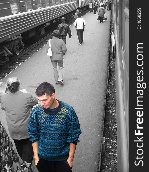 A Young man is walking on a train station
