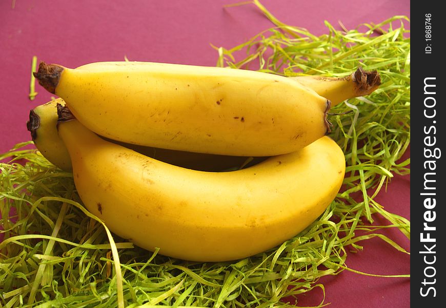 Three bananas in a pile on green paper. Three bananas in a pile on green paper