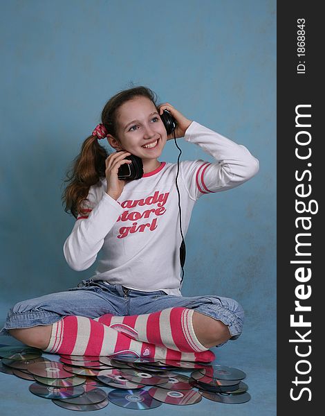 Smiling girl in headphones on a blue background