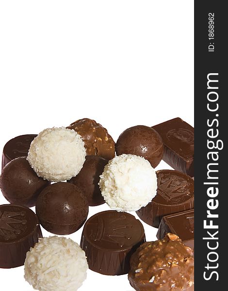Appetizing chocolate candies with a nut and coconut are sparse on a white background