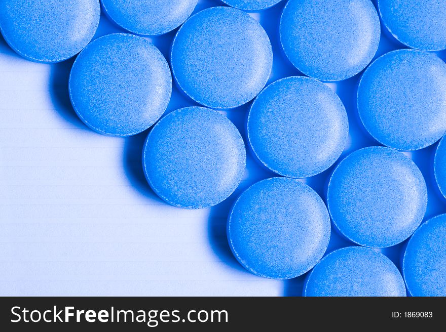 Round blue pills sit on a table.