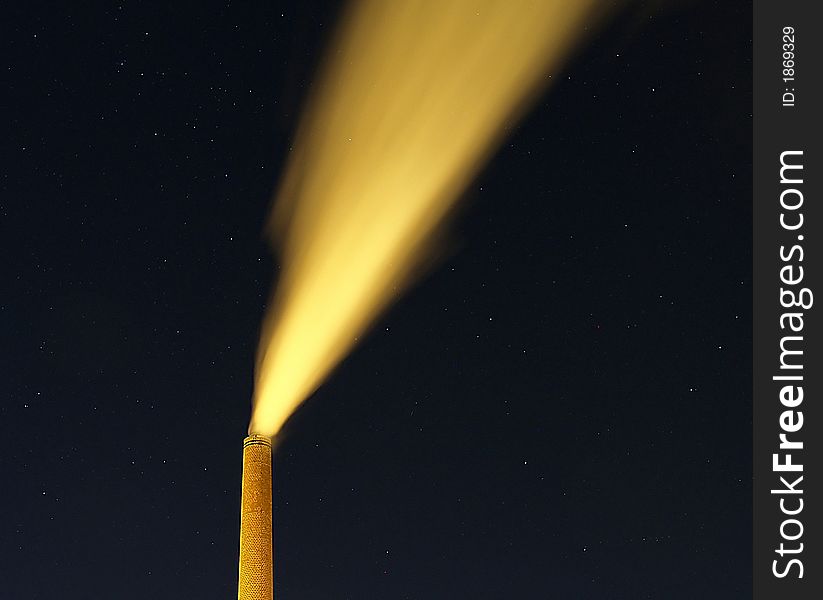 A brick chimney belches smoke into the night sky. A brick chimney belches smoke into the night sky.