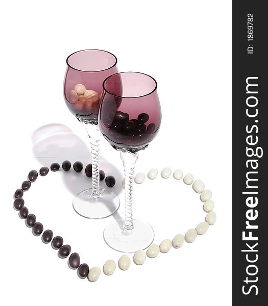 Two wineglasses in a heart shape made from candies artistic still life. Two wineglasses in a heart shape made from candies artistic still life