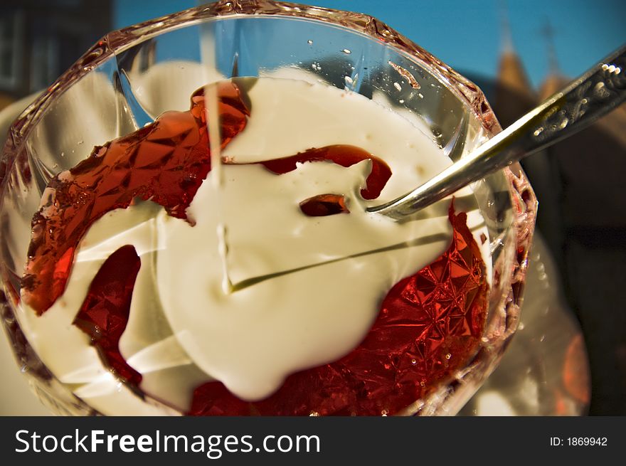 Red jelly with cream in a crystal bowl with silverware. Red jelly with cream in a crystal bowl with silverware