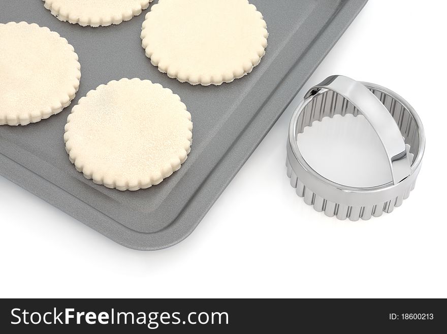 Pastry biscuit dough on a baking tray with cookie cutter, over white background. Pastry biscuit dough on a baking tray with cookie cutter, over white background.