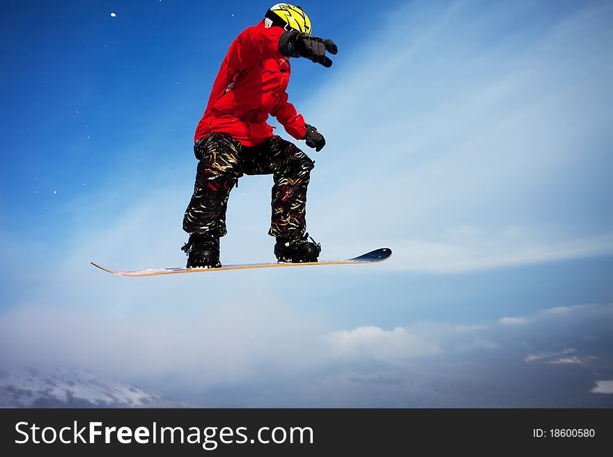 Snowboarder jumping through air with deep blue sky in background