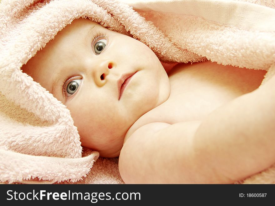 Baby looking out from under blanket