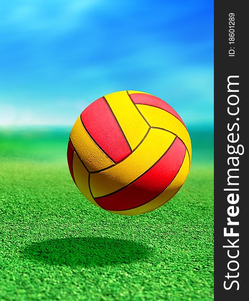 Multicolored ball on green ground in motion
