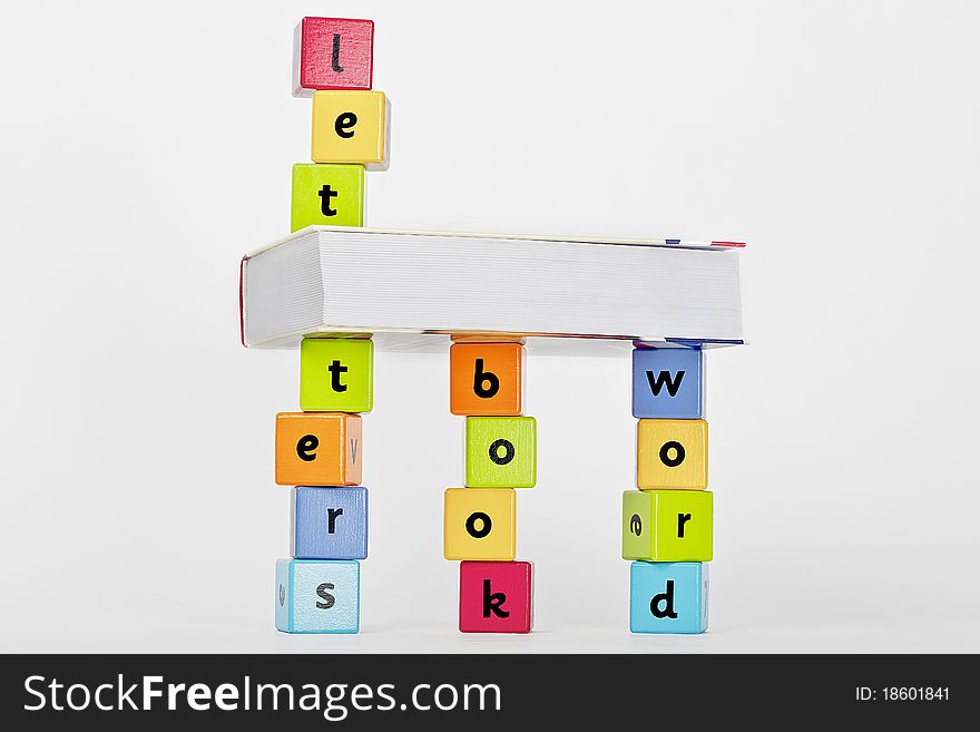 Book and wooden blocks with letters stacket up. Book and wooden blocks with letters stacket up