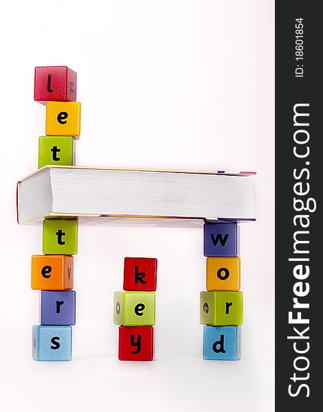 Book and wooden blocks with letters stacket up. Book and wooden blocks with letters stacket up