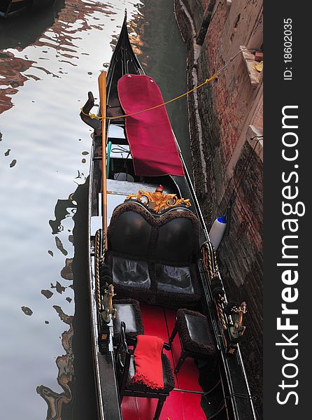 Details of an elegant gondola parked on a narrow canal in Venice,Italy. Details of an elegant gondola parked on a narrow canal in Venice,Italy.