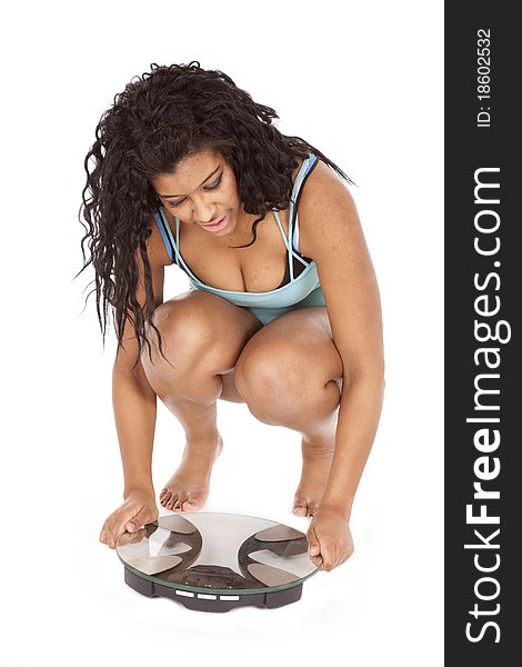 An African American woman is sitting by a set of scales. An African American woman is sitting by a set of scales.