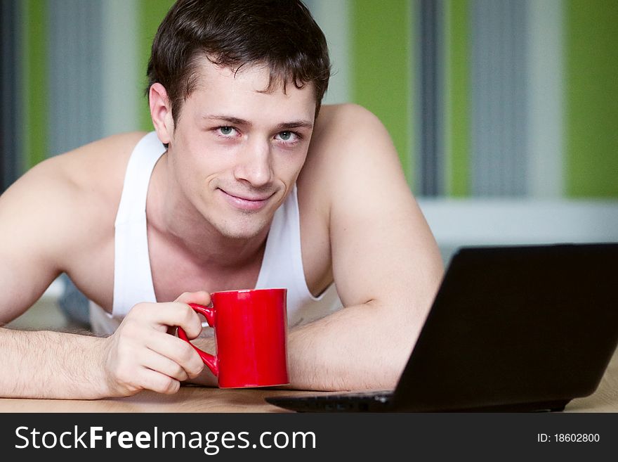 A Young Man In A White Robe With Laptop