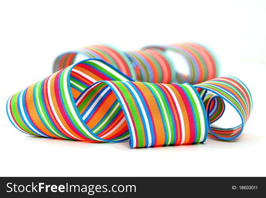 A multicolored striped ribbon coiled and curled on a white background. A multicolored striped ribbon coiled and curled on a white background