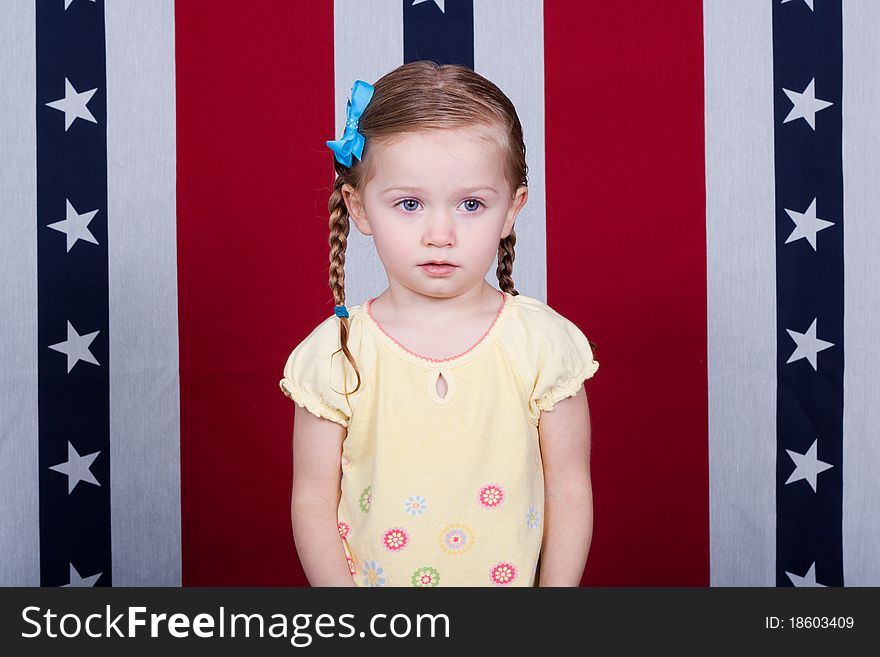 A confused child standing in front of an American Flag style background. A confused child standing in front of an American Flag style background.