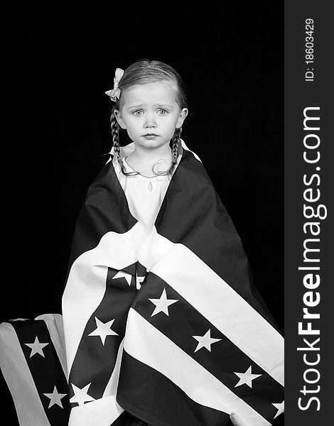 A girl clothed in an American flag design. The photograph is in black and white. A girl clothed in an American flag design. The photograph is in black and white.