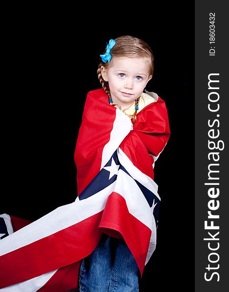 Girl with a confused look on her face. She is drapped in a patriotic design. There is a black background. Girl with a confused look on her face. She is drapped in a patriotic design. There is a black background.