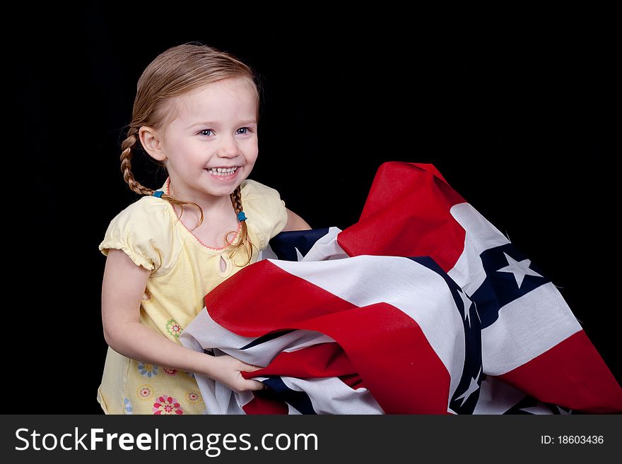 A cute girl folding/holding the American Flag. A cute girl folding/holding the American Flag