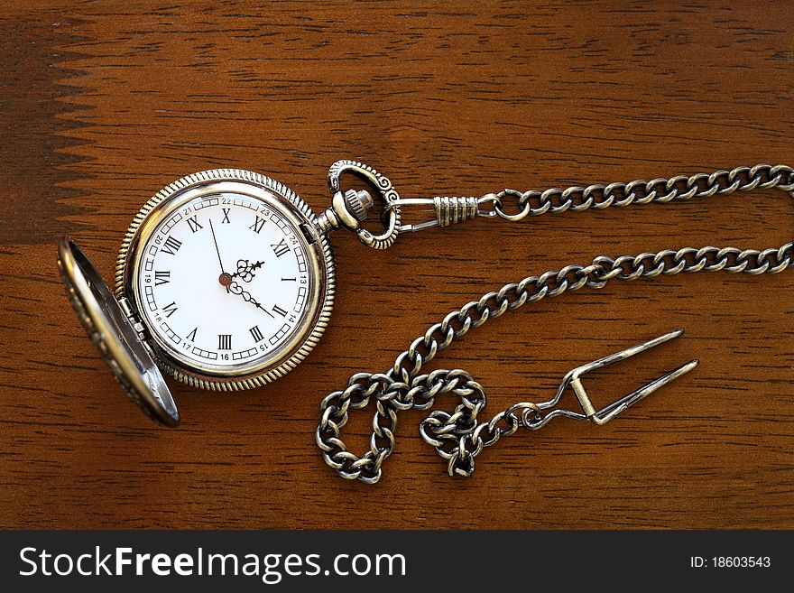 Antique pocket watch on a wood board