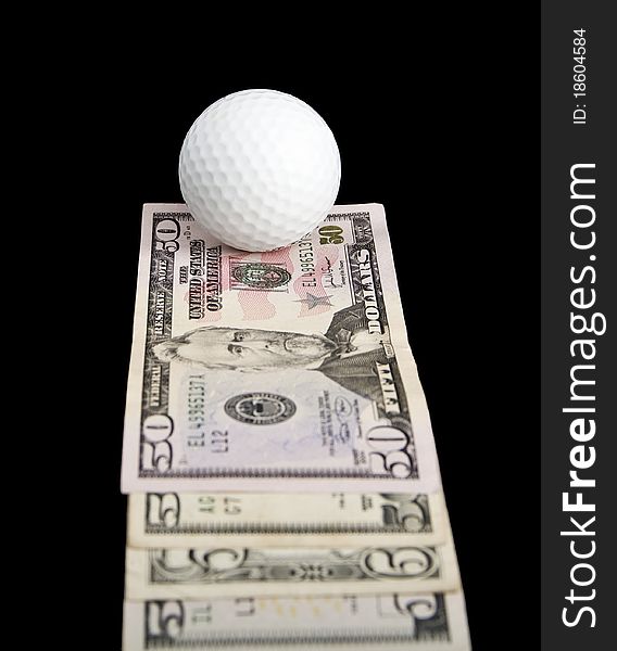 A ball for golf lies on notes on a black background. A ball for golf lies on notes on a black background