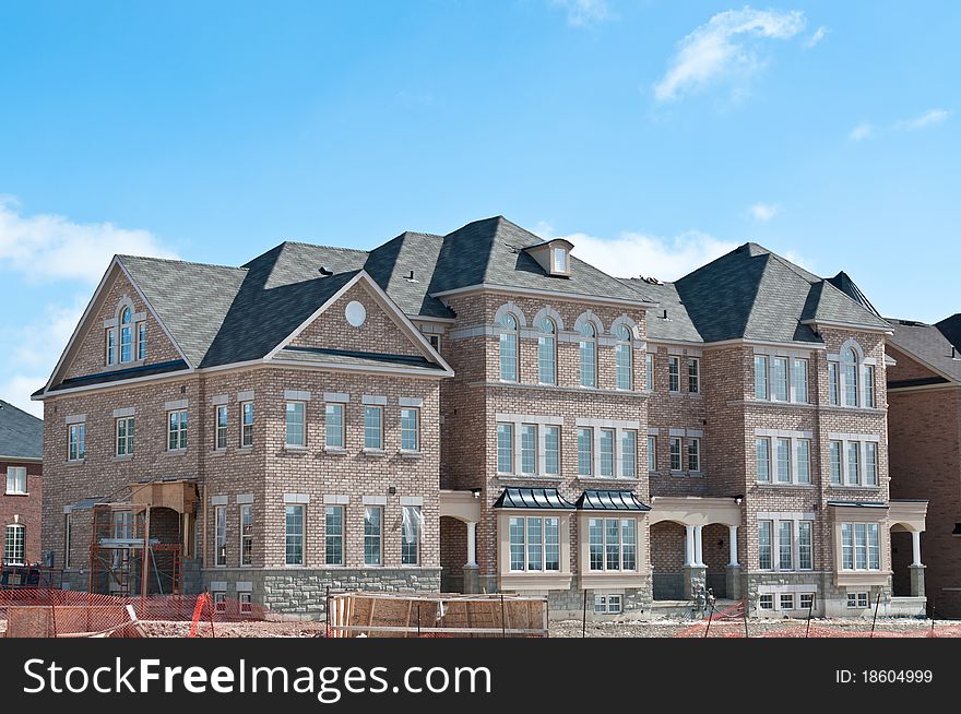 A newly built row of townhouses nears completion. A newly built row of townhouses nears completion.