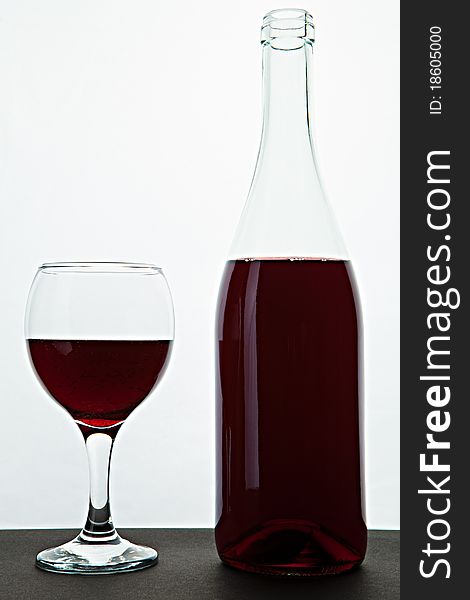 Open bottle and glass with red wine on a table