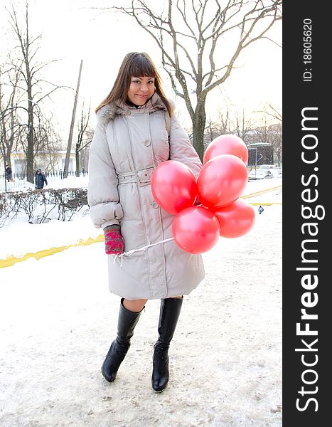 Portrai of beautiful smiling young girl with pink and red balloon in winter park. Portrai of beautiful smiling young girl with pink and red balloon in winter park