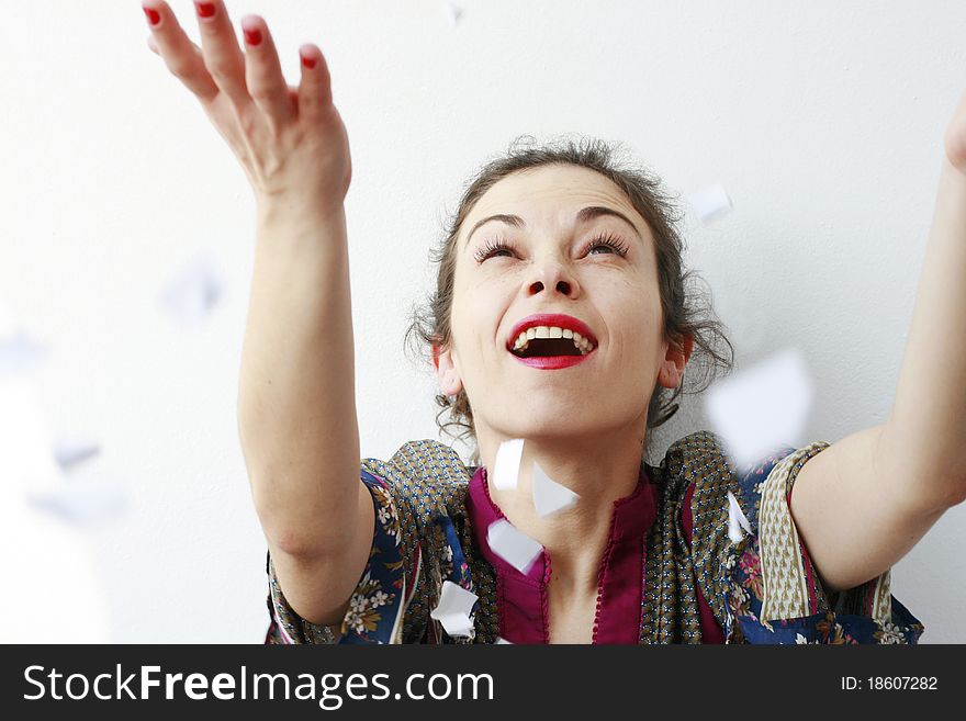 Happy woman throwing pieces of paper in the air laughing