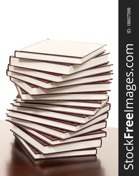 Stack of real books in wound formation, leather binder side view, isolated on white background