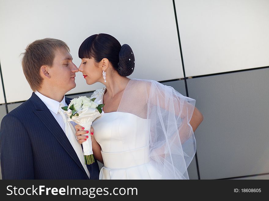 Bride and groom by the wall. Bride and groom by the wall