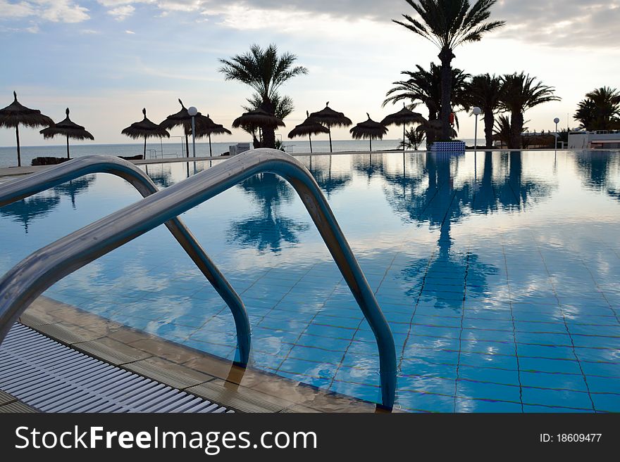 Swimming pool in tunisia with palms in background.