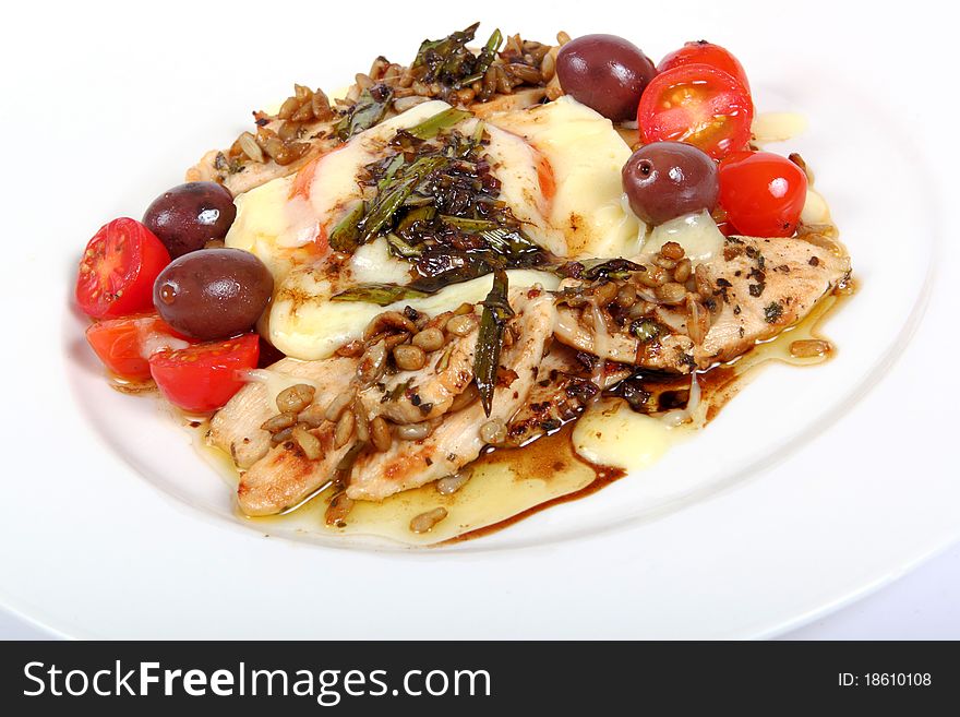 Mediterranean mozzarella dish with tomatoes herbs and chicken on a white plate