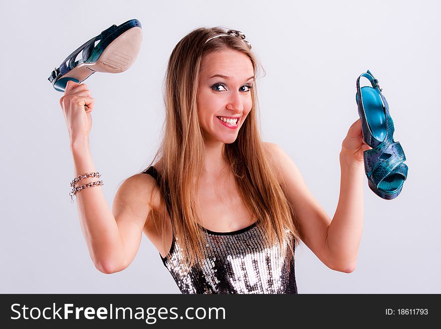 Pretty girl with a pair of shoes in hands