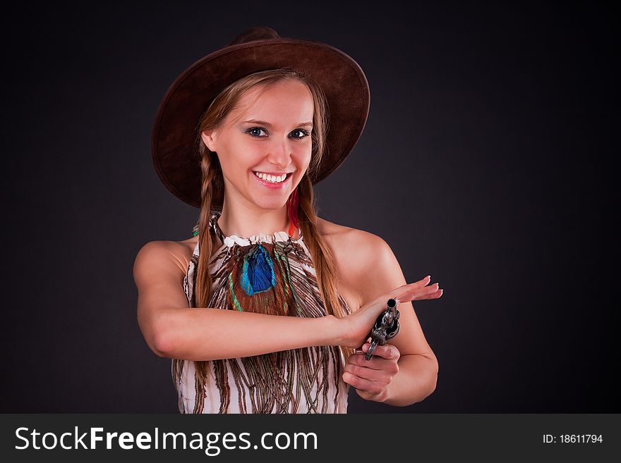 The American Indian girl in a cowboy's hat holds a pistol