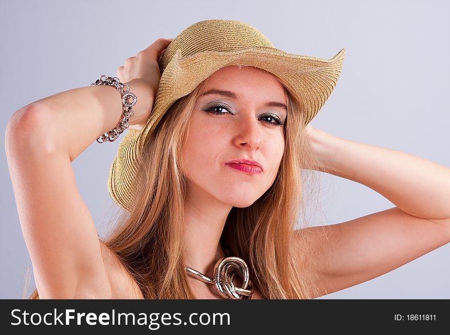 Attractive girl in a golden straw hat