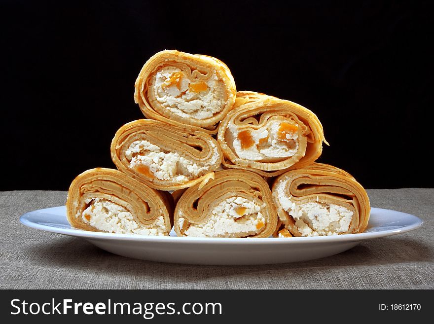 Pancakes with cottage cheese and dried apricots, rolled into rolls