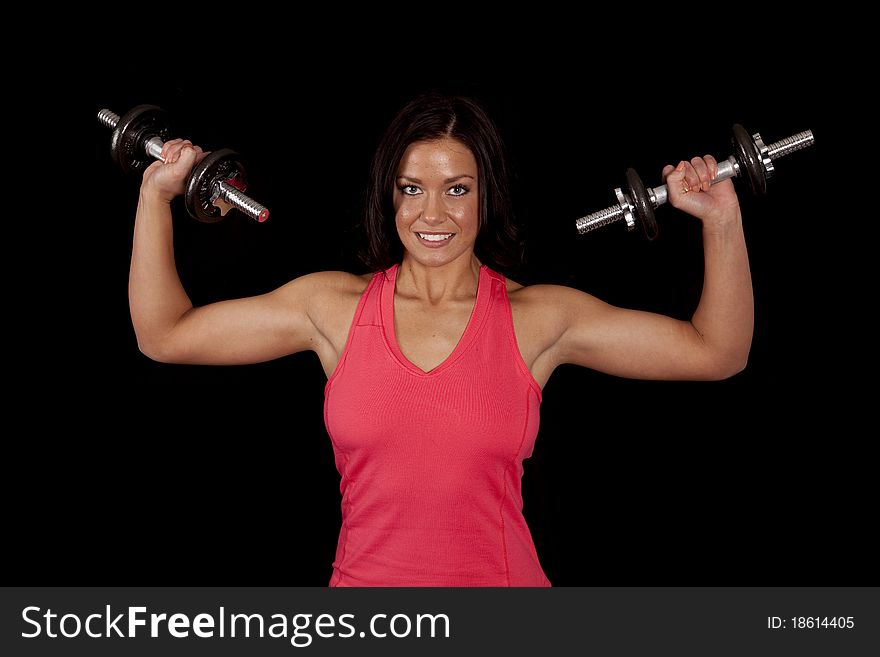 A woman is holding some weights with her muscles showing. A woman is holding some weights with her muscles showing