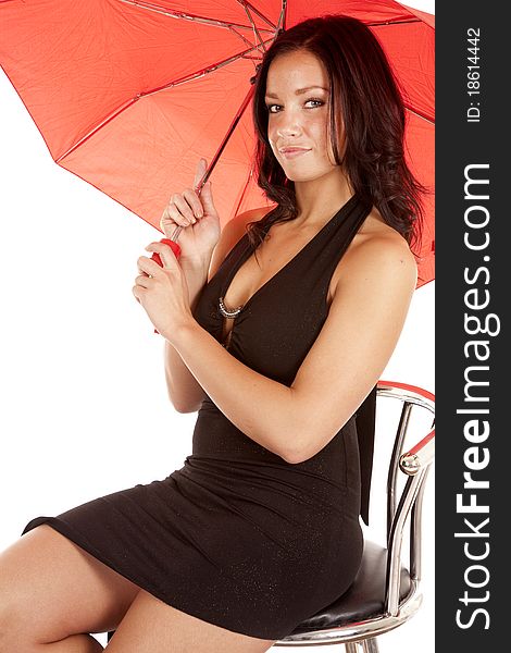 A woman in a black dress is holding a red umbrella. A woman in a black dress is holding a red umbrella