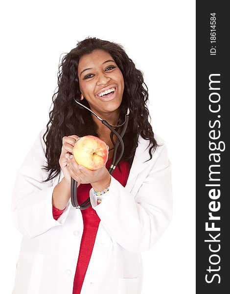 A woman with a stethoscope is listening to an apple and smiling. A woman with a stethoscope is listening to an apple and smiling.