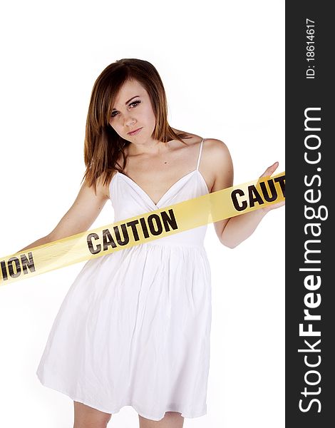 A woman in a white dress has caution tape in front of her. A woman in a white dress has caution tape in front of her.