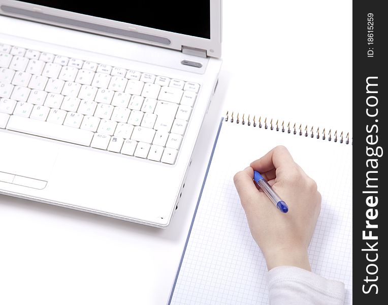 Business notebook with laptop and pen in hand.