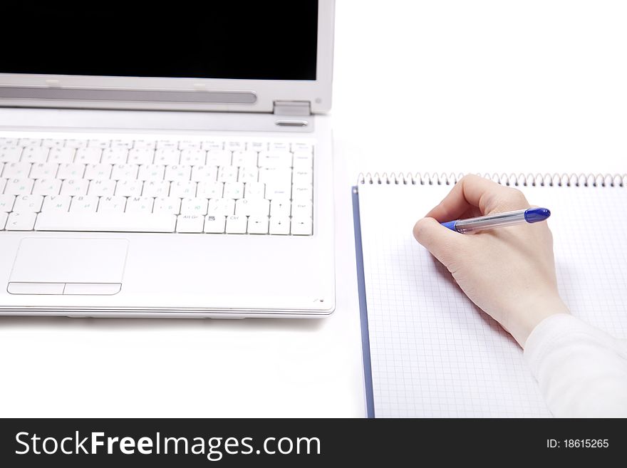 Business notebook with laptop and pen in hand. Studio shot.