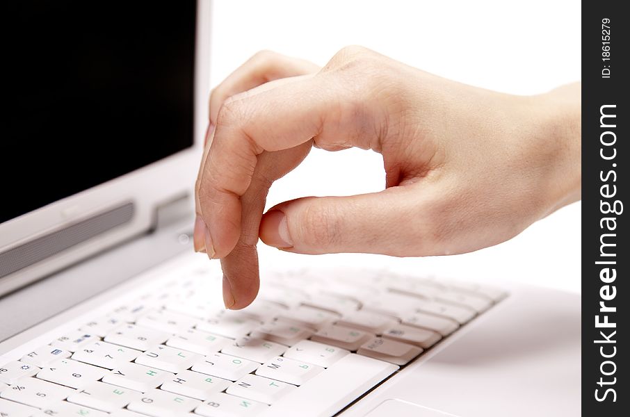 Human hand over laptop keypad during typing. Studio shot.