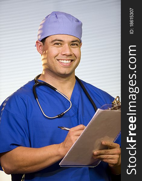 Close-up of young man wearing blue scrubs and surgical cap. Close-up of young man wearing blue scrubs and surgical cap.